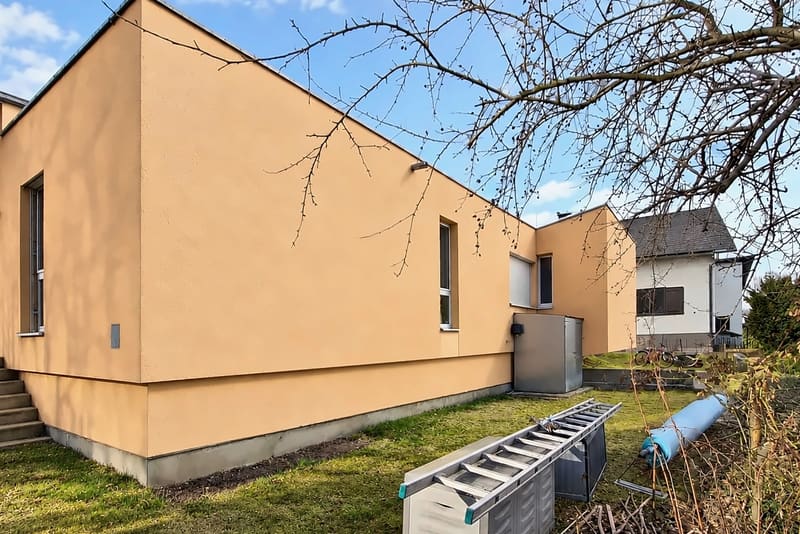 Derselbe Bungalow nach der Reinigung, der orangefarbene Putz wieder gleichmäßig in der Farbe